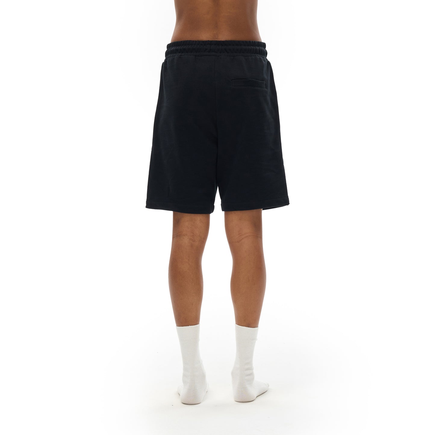 Person wearing black shorts and white socks standing on a white background.