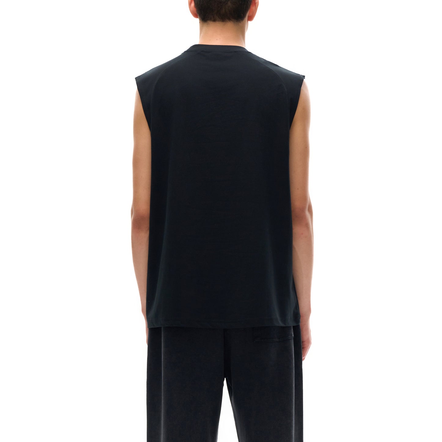 Person wearing a black sleeveless t-shirt and black sweatpants, facing away from the camera.