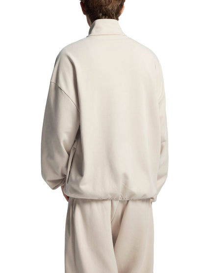 Person wearing a beige outfit on a white background