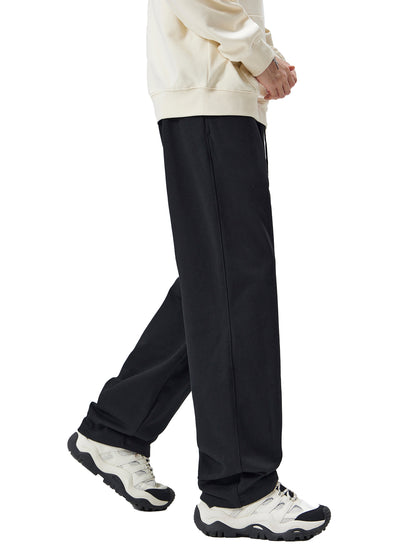 Person wearing black pants and white sneakers on a white background