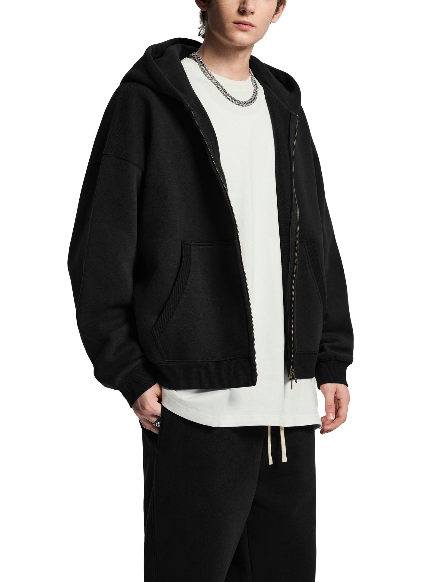 Person wearing a black hoodie over a white shirt on a white background