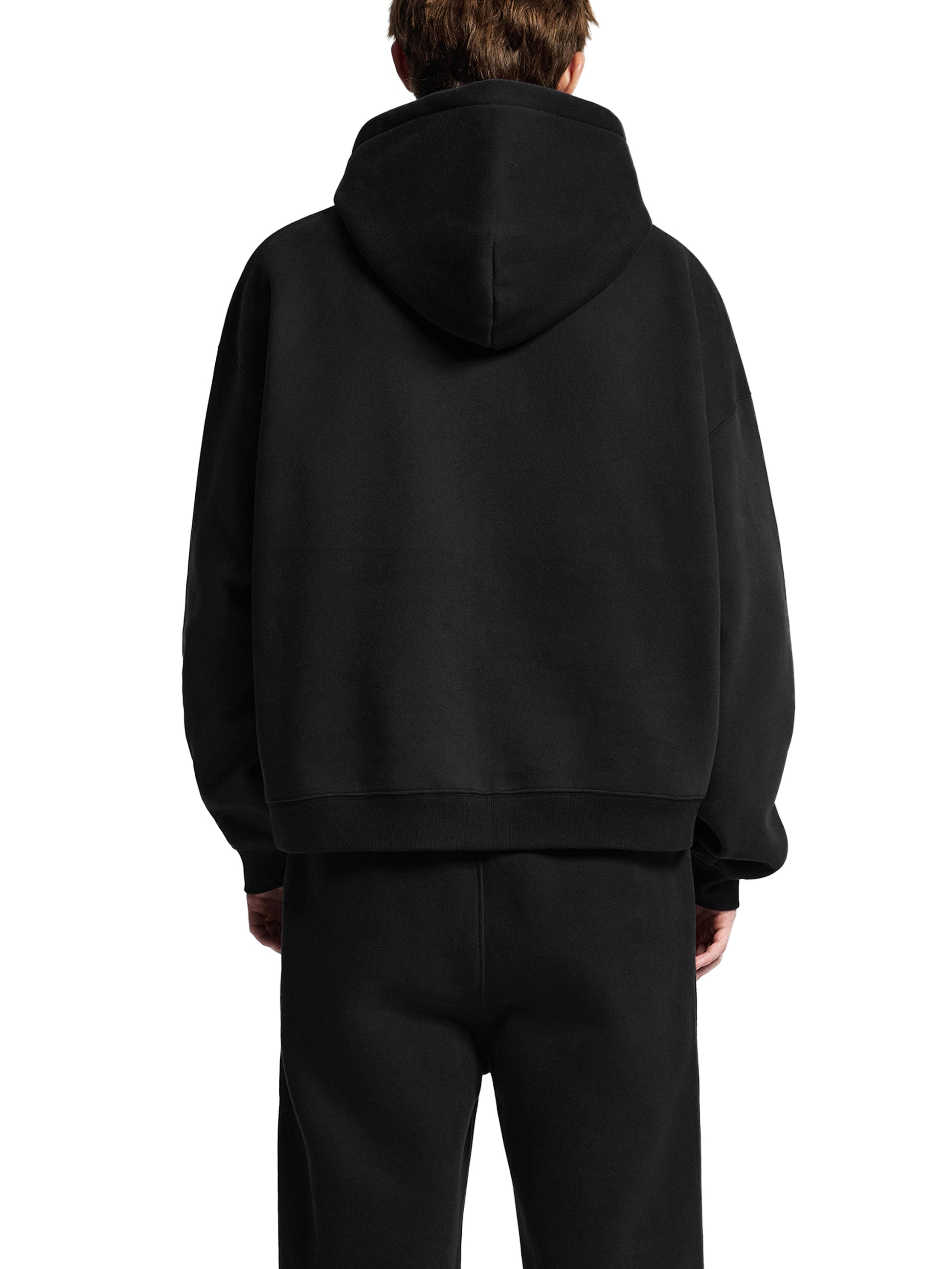 Person wearing a black hoodie from behind on a white background