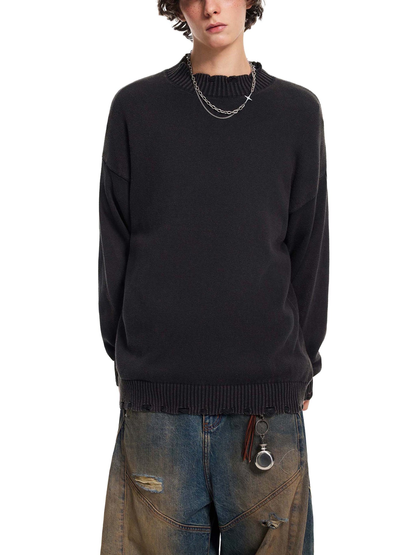 Person wearing a black sweater and jeans on a white background