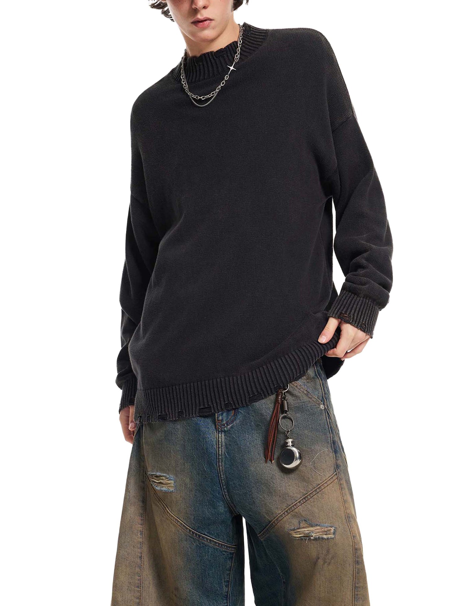 Person wearing a black sweater and blue jeans on a white background