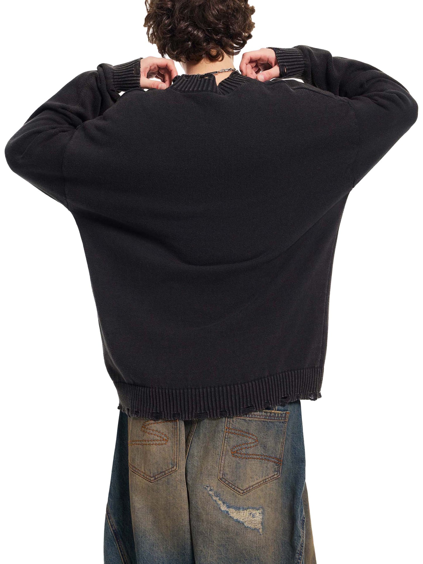 Person wearing a black sweater and jeans from behind on a white background