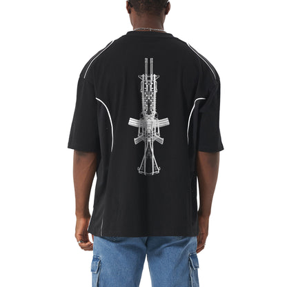 Man in black t-shirt with a gun graphic and blue jeans from behind.