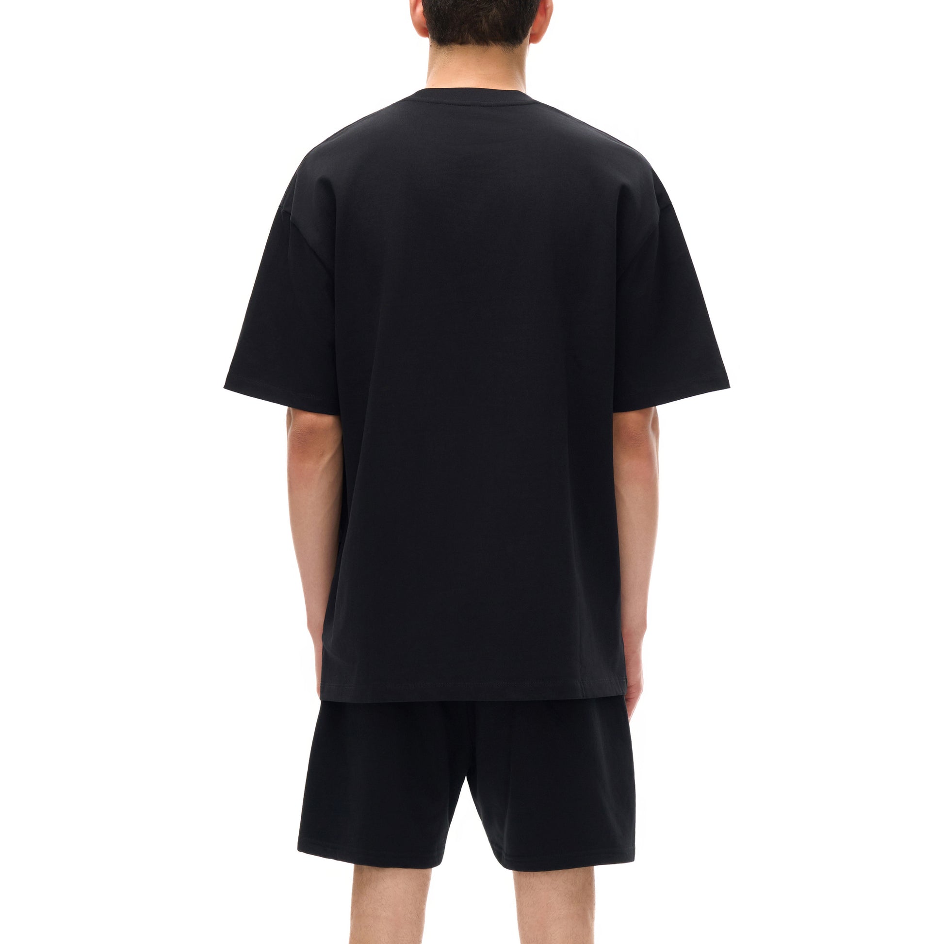 Back view of a person in black t-shirt and shorts.