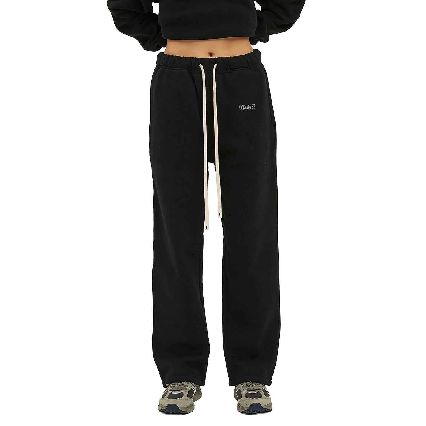 Black sweatpants with a drawstring and sneakers.