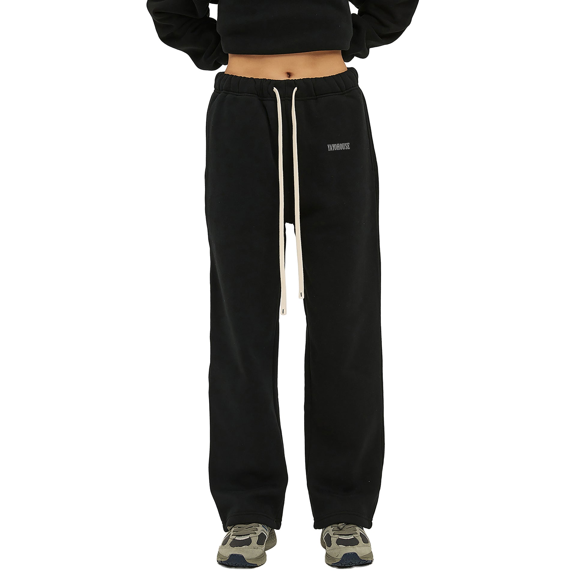 Black sweatpants with a drawstring and sneakers.