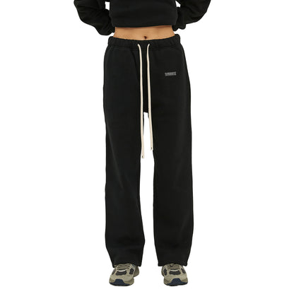 Black sweatpants with a drawstring and sneakers.